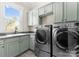 The laundry room features modern appliances, built-in cabinets and granite countertops at 132 Tuskarora Point Ln, Mooresville, NC 28117