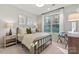 Bright bedroom with a comfortable bed, side tables, and a large window overlooking a serene backyard at 13308 Chopin Ridge Rd, Huntersville, NC 28078