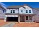 New construction home featuring a covered entry, two-car garage and visible Tyvek HomeWrap at 13308 Chopin Ridge Rd, Huntersville, NC 28078