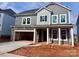 Charming two-story home with gray siding, stone accents, covered entry, and an attached two-car garage at 13308 Chopin Ridge Rd, Huntersville, NC 28078