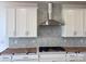 Modern kitchen featuring white cabinets, stainless steel range hood, and stylish backsplash at 13308 Chopin Ridge Rd, Huntersville, NC 28078