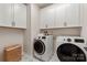 Well-equipped laundry room with modern washer and dryer units and ample cabinet storage at 13308 Chopin Ridge Rd, Huntersville, NC 28078