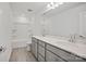 Bright bathroom featuring double vanity with gray cabinets, tub-shower combo, and neutral tile flooring at 13744 Roderick Dr # 173, Huntersville, NC 28078