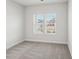 A bedroom with neutral carpet and white walls, showcasing natural light through a window at 1418 Windy Park Dr, Stanley, NC 28164