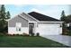 Charming single-story home showcasing a well-manicured lawn, a two-car garage and a blend of gray and white siding at 1418 Windy Park Dr, Stanley, NC 28164