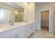 Bright bathroom featuring double vanity, a large mirror, quartz countertops and walk-in closet at 1422 Windy Park Dr, Stanley, NC 28164
