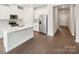 Well-lit kitchen featuring a stainless steel refrigerator, an island, and hardwood floors at 1422 Windy Park Dr, Stanley, NC 28164