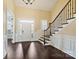 The open foyer features hardwood floors, a staircase with decorative iron railings, and plenty of natural light at 14629 Glen Valley Ct, Charlotte, NC 28278
