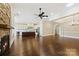 Spacious living room with hardwood floors, stone fireplace, open kitchen and a modern ceiling fan at 14629 Glen Valley Ct, Charlotte, NC 28278