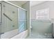 Bathroom features a shower-tub combo with glass doors and vintage green tiling at 223 Oakland Cir, Newton, NC 28658