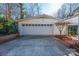 Detached two-car garage with white siding and door, complemented by a brick paved area, adjacent to the back yard at 223 Oakland Cir, Newton, NC 28658