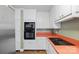 Modern kitchen featuring white cabinets, stainless steel appliances, and retro orange countertops at 223 Oakland Cir, Newton, NC 28658