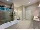 Bathroom features a glass shower, soaking tub, double doors and modern vanities at 2302 Rayecliff Ln, Charlotte, NC 28214