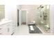 Modern bathroom with a glass-enclosed shower, bench, and white vanity offers a spa-like experience at 2302 Rayecliff Ln, Charlotte, NC 28214