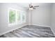 Spacious bedroom featuring gray-toned wood floors, lots of light, and ceiling fan at 2302 Rayecliff Ln, Charlotte, NC 28214