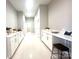 Bright hallway features white cabinets, countertops, and a workspace with stool, enhancing its spacious and functional feel at 2302 Rayecliff Ln, Charlotte, NC 28214