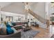 Open-concept living room featuring a soaring ceiling, wood floors, and a staircase at 258 Ridge Reserve Dr, Lake Wylie, SC 29710