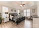 Serene bedroom with a black patterned bed, hardwood floors, and plantation shutters at 258 Ridge Reserve Dr, Lake Wylie, SC 29710