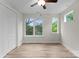 Sunlit bedroom featuring wood floors, a ceiling fan, and large windows with picturesque outdoor views at 3202 Riley Ave, Charlotte, NC 28269