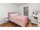Bedroom with hardwood floors, a fluffy pink bed, a vanity, and natural light from the window at 3428 Braewick Pl, Charlotte, NC 28227