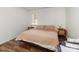 Cozy bedroom featuring hardwood floors, neutral bedding, bedside tables, and a changing table near the window at 3428 Braewick Pl, Charlotte, NC 28227