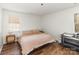 Bedroom with hardwood floors, a comfortable bed, and a window providing natural light, adjacent to a changing table at 3428 Braewick Pl, Charlotte, NC 28227