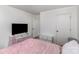 Bright bedroom featuring hardwood floors, a cozy pink bed, and ample storage with a TV setup at 3428 Braewick Pl, Charlotte, NC 28227