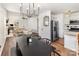 Dining area adjacent to kitchen and living room, showcasing modern lighting and seating for a seamless entertaining space at 3428 Braewick Pl, Charlotte, NC 28227