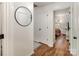 Hallway featuring a round mirror and wood flooring that leads to a bedroom with a neutral color palette at 3428 Braewick Pl, Charlotte, NC 28227