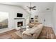 Cozy living area with a painted brick fireplace, wood floors, and comfortable seating, creating a warm ambiance at 3428 Braewick Pl, Charlotte, NC 28227