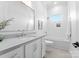 Modern bathroom featuring sleek white tiling, vanity with sink, large mirror, and a window-lit shower-tub combo at 4207 Walker Rd, Charlotte, NC 28211