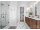 Luxurious bathroom featuring a glass-enclosed shower, double vanity, and a glimpse into a spacious walk-in closet at 4207 Walker Rd, Charlotte, NC 28211
