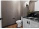 Elegant powder room with patterned wallpaper, modern fixtures, and a sleek black countertop at 4207 Walker Rd, Charlotte, NC 28211
