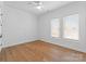 Bright bedroom with hardwood floors, ceiling fan and natural light from two large windows at 4207 Walker Rd, Charlotte, NC 28211