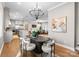 This dining room showcases a modern chandelier, an oval dining table, and a view into a large living room and kitchen at 4207 Walker Rd, Charlotte, NC 28211