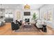 Open-concept living room and kitchen featuring hardwood floors, fireplace, and modern decor at 4207 Walker Rd, Charlotte, NC 28211