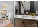 Stylish powder room with dark walls, gold-trimmed mirror, and a glimpse into the open living area at 4207 Walker Rd, Charlotte, NC 28211