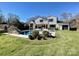 Stunning backyard with pool, waterfall, lush landscaping, and a white house at 500 Chillingworth Ln, Charlotte, NC 28211