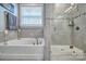 Bright bathroom features a glass enclosed shower and separate soaking tub with chrome fixtures at 5050 Watersail Way, Lake Wylie, SC 29710