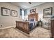 Bedroom featuring a grand wooden bed, unique wall art, and neutral tones at 5050 Watersail Way, Lake Wylie, SC 29710