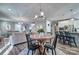 Open concept dining area with a wooden table, modern chandelier, and views of the living room and kitchen at 5050 Watersail Way, Lake Wylie, SC 29710