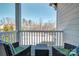 Outdoor porch with two dark wicker chairs with green cushions and wooded views at 5050 Watersail Way, Lake Wylie, SC 29710