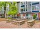 Cozy outdoor fire pit area with stone benches, brick pavers, and lush greenery at 509 N Graham St # 2D, Charlotte, NC 28202