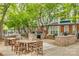 Outdoor dining area with multiple picnic tables, grilling stations, and mature trees at 509 N Graham St # 2D, Charlotte, NC 28202
