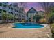 Community pool with a brick surround and several apartment buildings in the background at 525 N Graham St # 3B, Charlotte, NC 28202