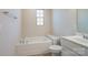 Bathroom features a soaking tub, toilet, vanity with sink and fixtures, and window at 5337 Orchid Bloom Dr, Indian Land, SC 29707
