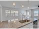Modern kitchen island featuring pendant lighting, stainless sink and granite countertops at 5337 Orchid Bloom Dr, Indian Land, SC 29707