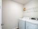 Well-lit laundry room featuring a white washer and dryer, along with a wire shelving unit for storage at 5337 Orchid Bloom Dr, Indian Land, SC 29707