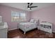 Cozy bedroom featuring hardwood floors, neutral walls, ceiling fan, and bright natural light at 6621 Fair Lawn Rd, Charlotte, NC 28215