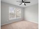 The bedroom includes neutral carpet, ceiling fan, and lots of light from the large windows at 9413 Pastern Ct, Charlotte, NC 28216